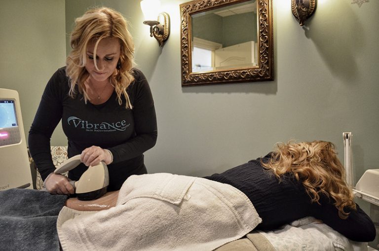 Medical aesthetician doing Coolsculpting treatment on woman's thigh