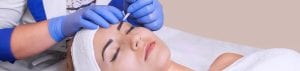 Woman getting permanent eyeliner makeup cosmetic procedure.