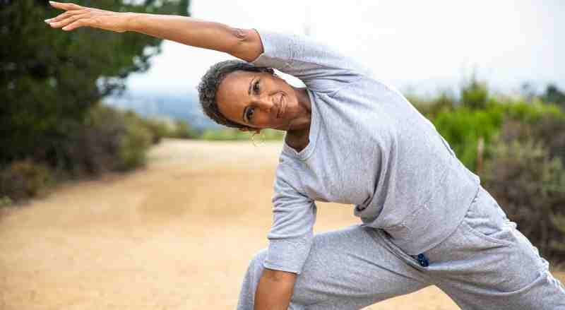 A senior woman is doing yoga to stay fit highlighting her regular exercise routine