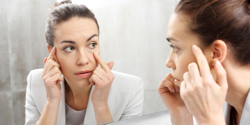 Woman looking at herself in the mirror with concern