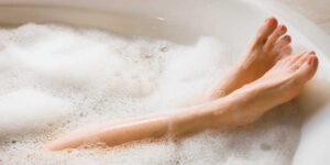 A woman’s legs in a stress relieving bubble bath