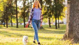 An energized woman walks her dog in the park