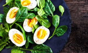 A platter of hard-boiled eggs and fresh spinach