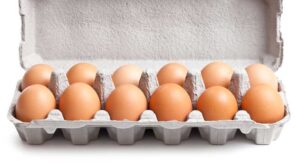 A dozen brown eggs in an opened egg carton