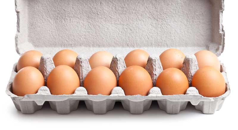 A dozen brown eggs in an opened egg carton