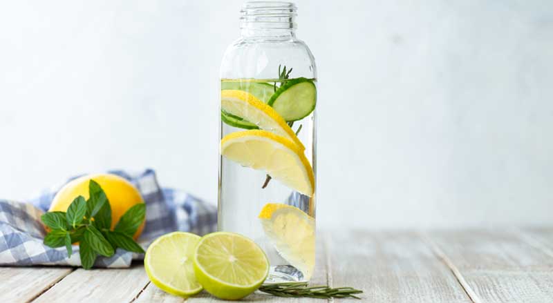 A bottle of water with lemon and lime slices in it.