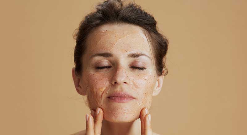 A woman applying an exfoliation product to her face