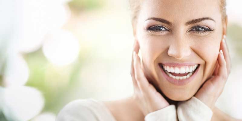 meditation-a-glow-from-within Closeup portrait of an attractive mid 30's woman gently touching her neck and with a glowing smile, meditation-a-glow-from-within